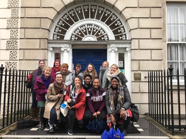 The Georgetown group poses in front of the blue door of the Royal College of Midwives in London.