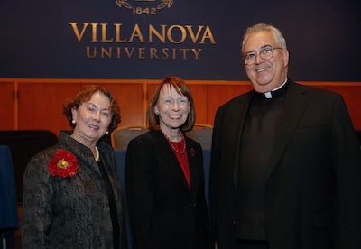 At the awards ceremony, in front of a Villanova University sign, are, left to right, Dean Donna S. Havens, Dr. Patricia Grady, and Dean Donna S. Havens, President Peter M. Donohue, OSA. 