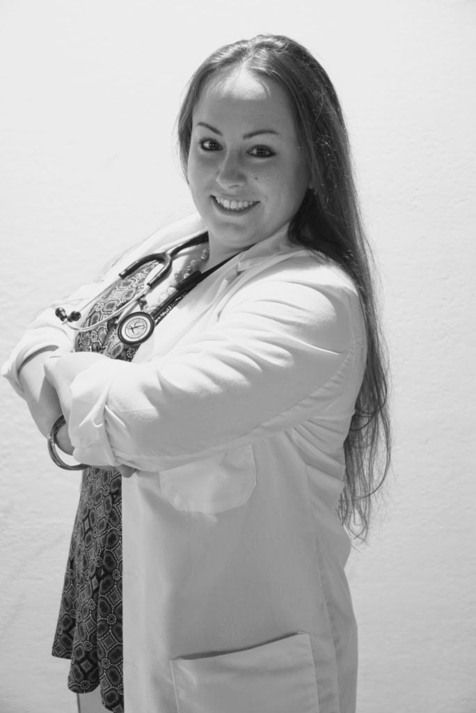 Arielle Tango (G’21) in her clinical attire in a black and white photo