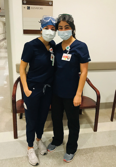 Ani Bilazarian (NHS’17) and Caroline Kechejian (NHS’17) stand together in surgical scrubs in a hospital hallway.