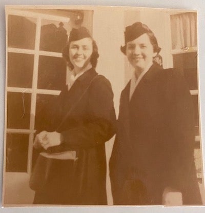 Two nursing students dressed in their visiting nurses association uniforms.
