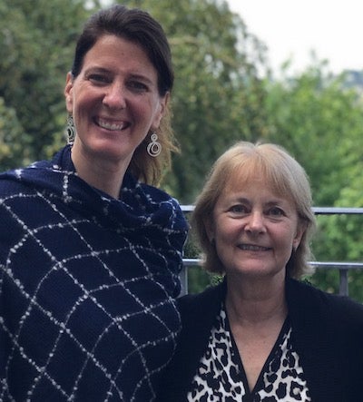 Professor Heather Bradford and Dr. Cynthia Farley pose together in front of a forest.
