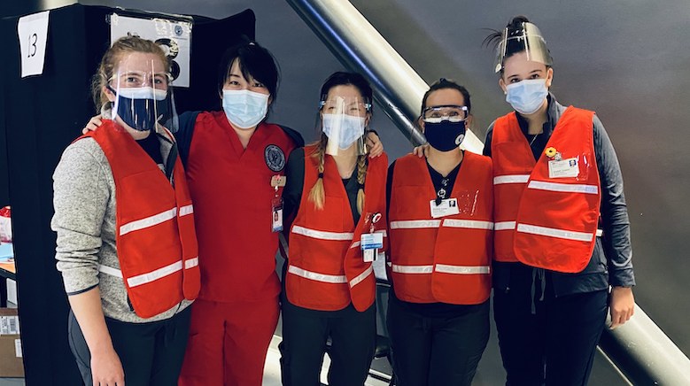 Students pose in a line in their clinical attire