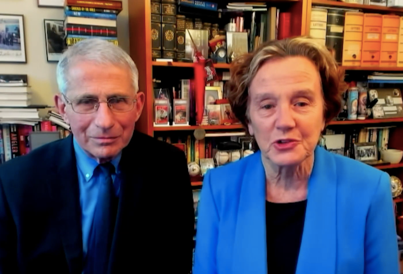 In a screenshot from their 2021 Commencement video message to Georgetown graduates Dr. Anthony Fauci and Dr. Christine Grady sit next to one another in front of bookshelves.