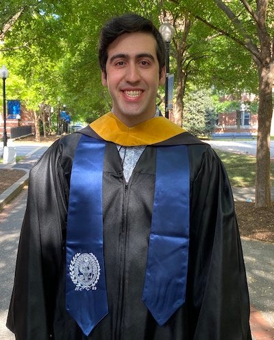 Joseph Maccarone, in his graduation gown and stole with the university seal, on Georgetown University's campus