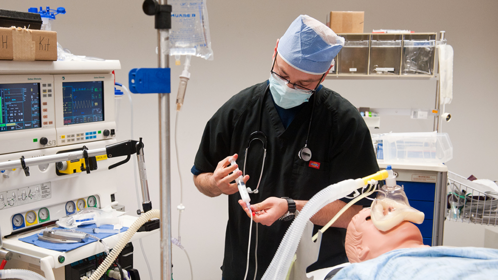 A nursing student administers a simulated medication in the Sim Lab