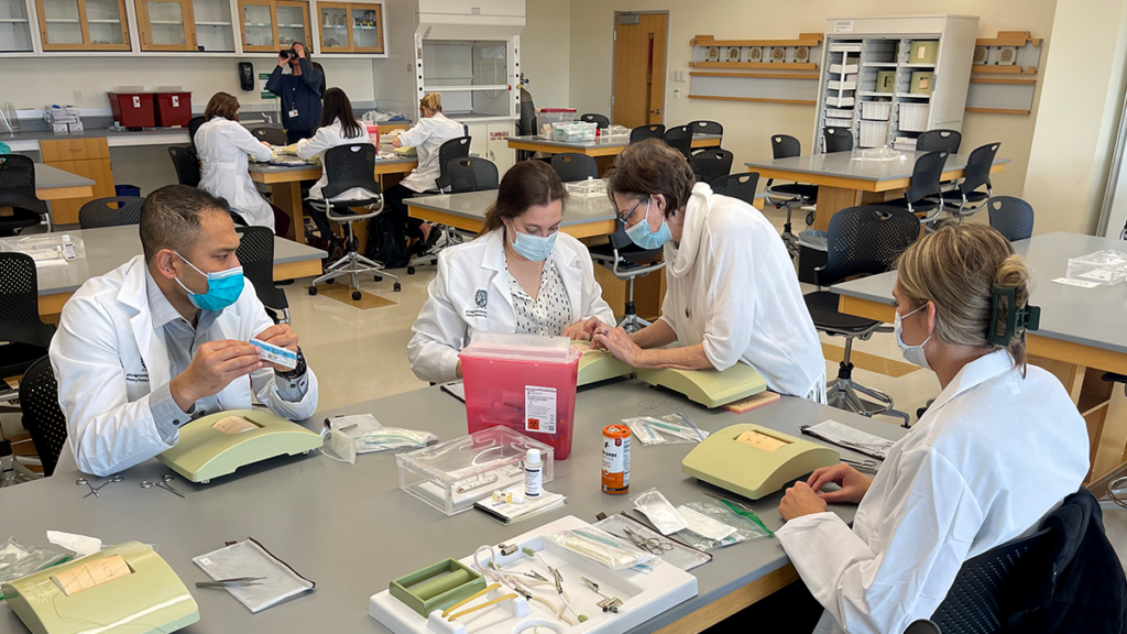FNP nursing students work in a lab class on a simulation