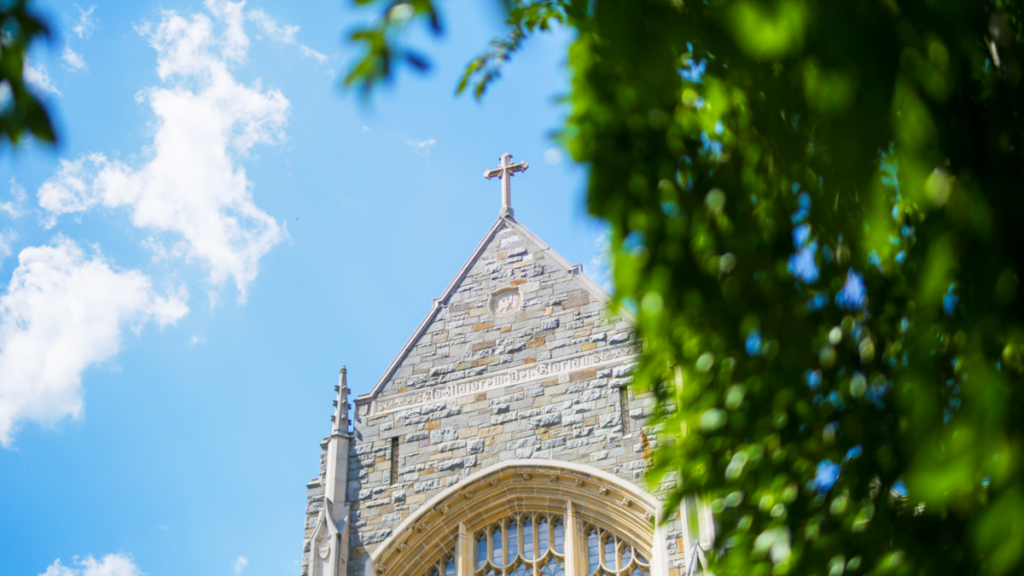 Building detail of a cross against a blue sky