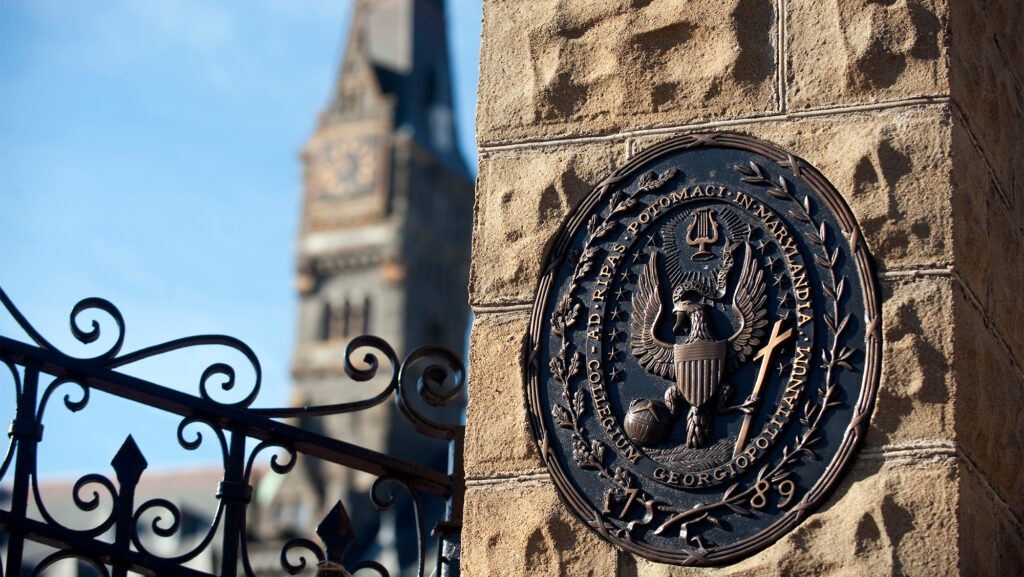 The front gate of campus displaying Georgetown University's seal in bronze