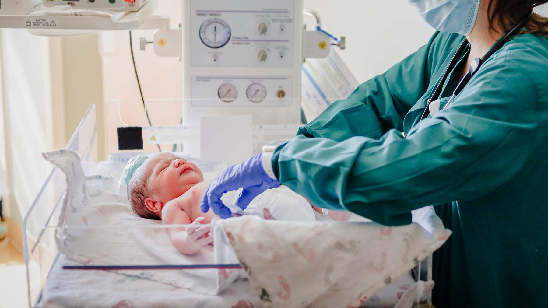 A newborn is cared for by a nurse in a hospital