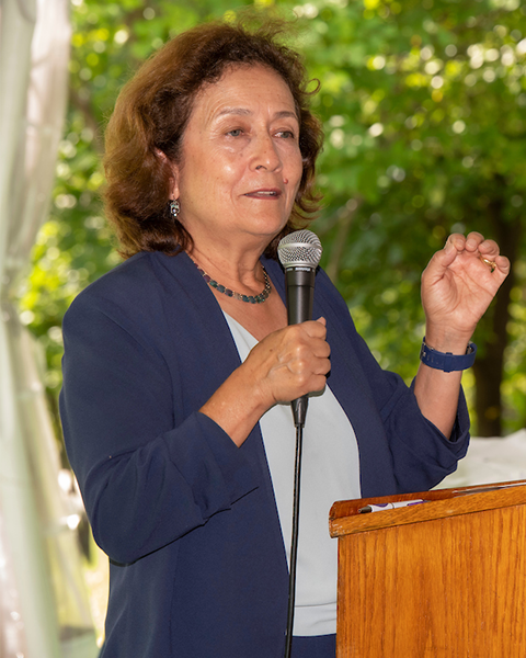 Maria Gomez speaks from a podium