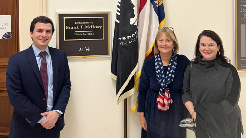 Three individuals stand in a hallway on Capitol Hill