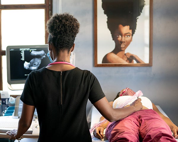 A woman administers an ultrasound to a pregnant woman