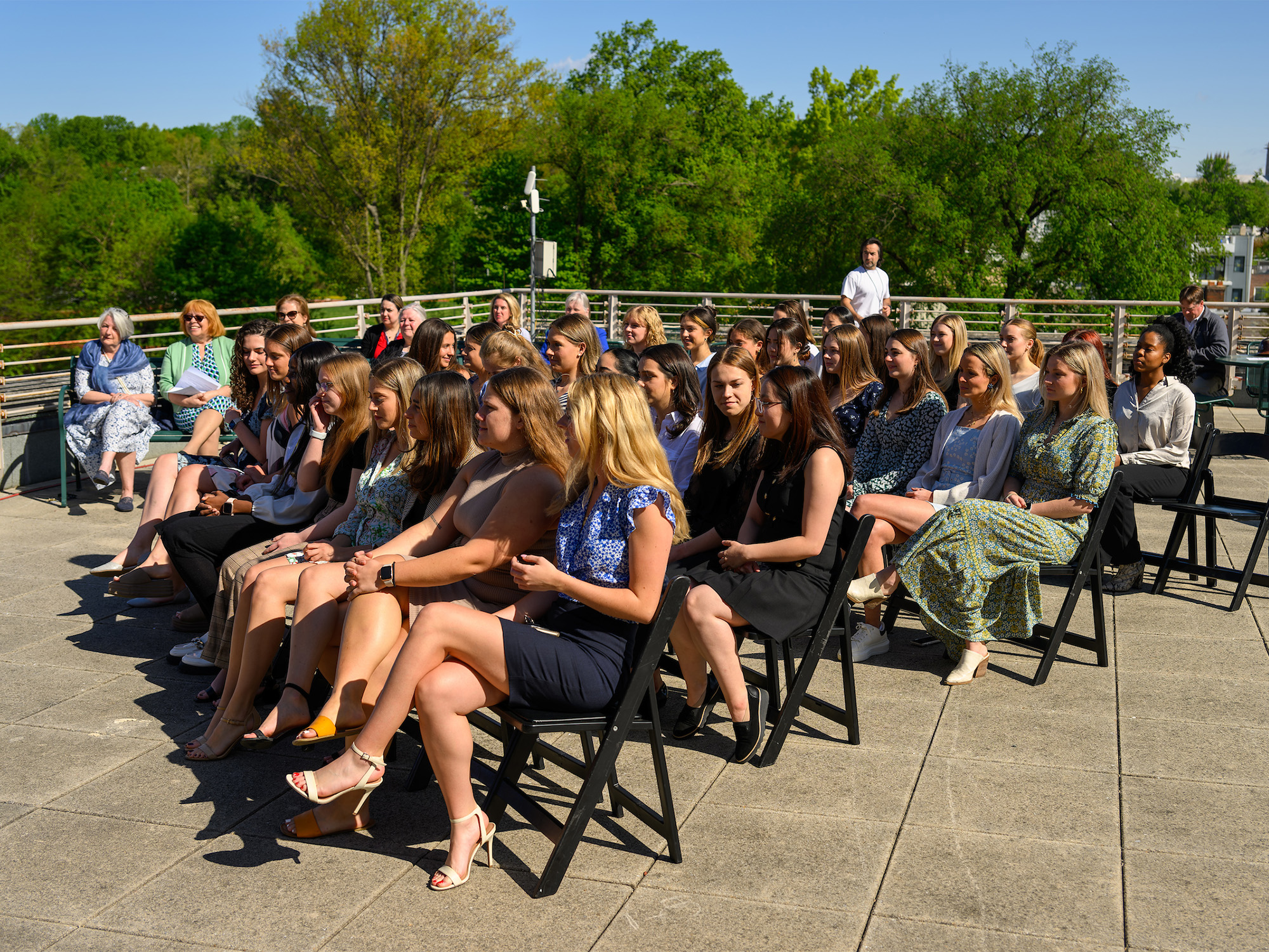 Students sit in chairs on the rooftop of St. Mary's Hall for their ceremony