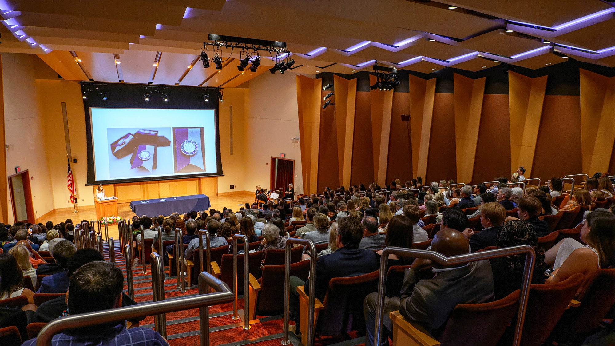 An auditorium filled with people attending the Pinning ceremony