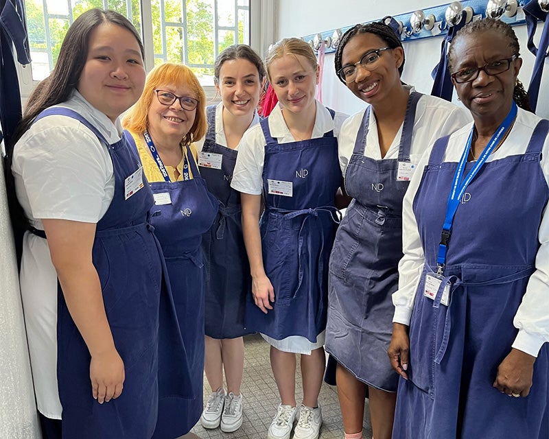 Four students and two faculty members dressed in traditional nursing garb prepare to volunteer at the baths at Lourdes