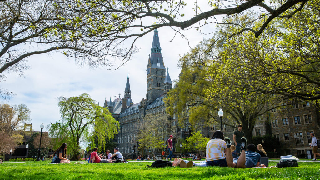 Georgetown in springtime with students sitting out on Healy Lawn