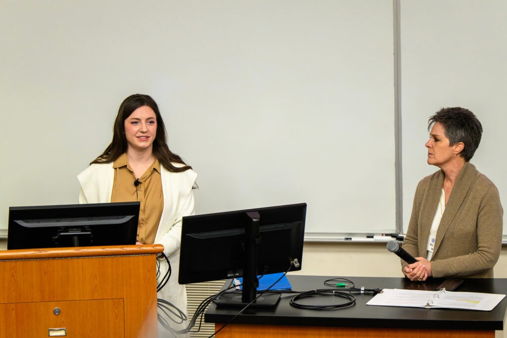 A student speaks while Dr. White stands nearby