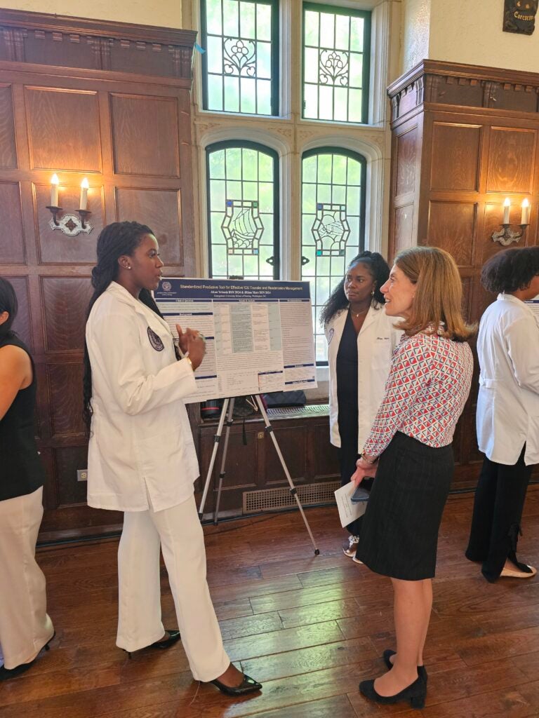 A student presents their poster to attendees