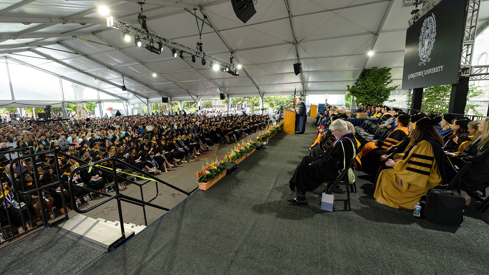 A view of the stage at Commencement as well as the audience of graduates and their supporters