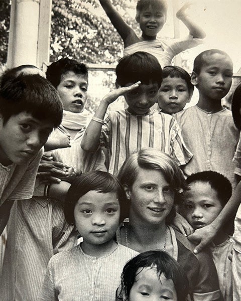 A young Tish Polger-Bailey is surrounded by Vietnamese orphans