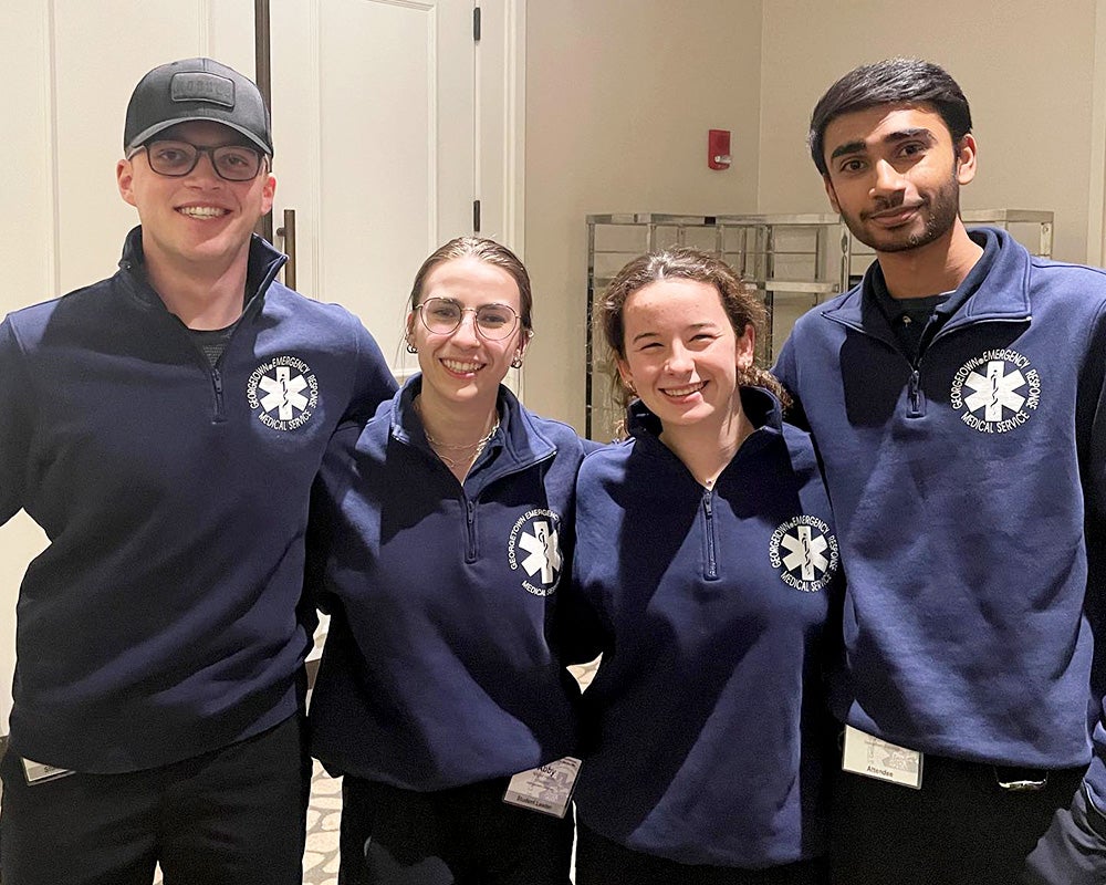 Four GERMS volunteers stand side by side in uniform