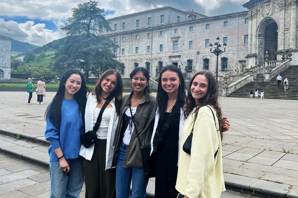 Five students stand together at an historic site