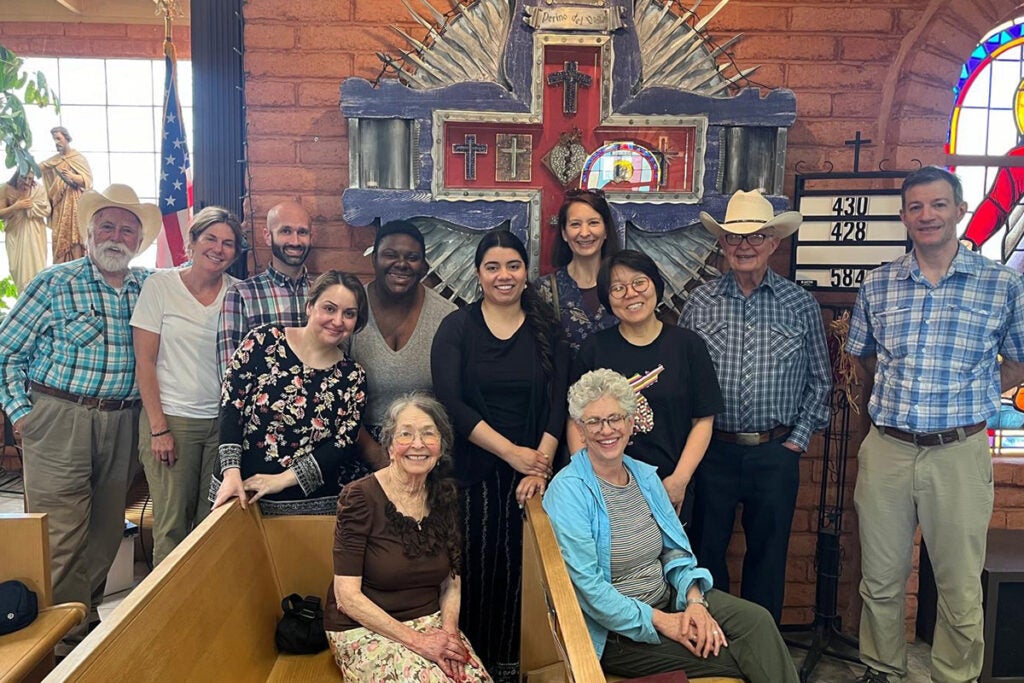 A group of people stands and sits together in a church