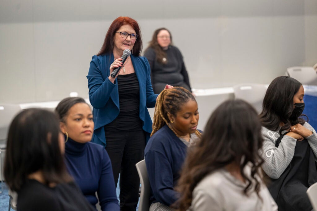 Lisa Caplin, DNP, NP-C, stands to ask a question during an oral presentation.