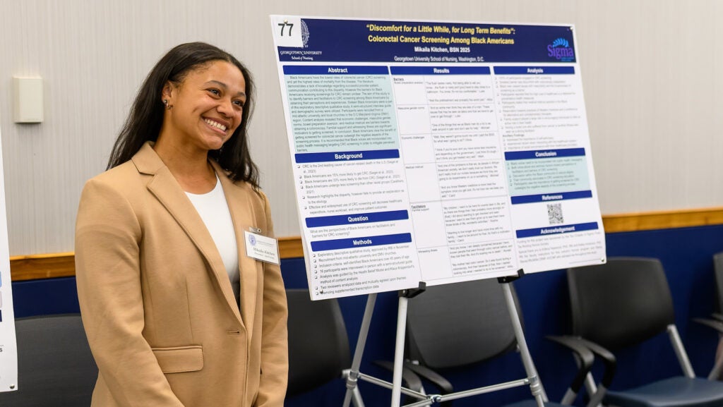 Mikaila stands next to the poster of her project