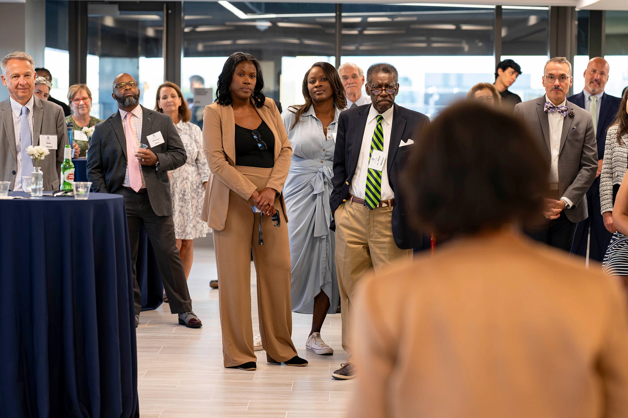 Beverly Malone speaks to the gathering, among which Jennifer and her father are standing