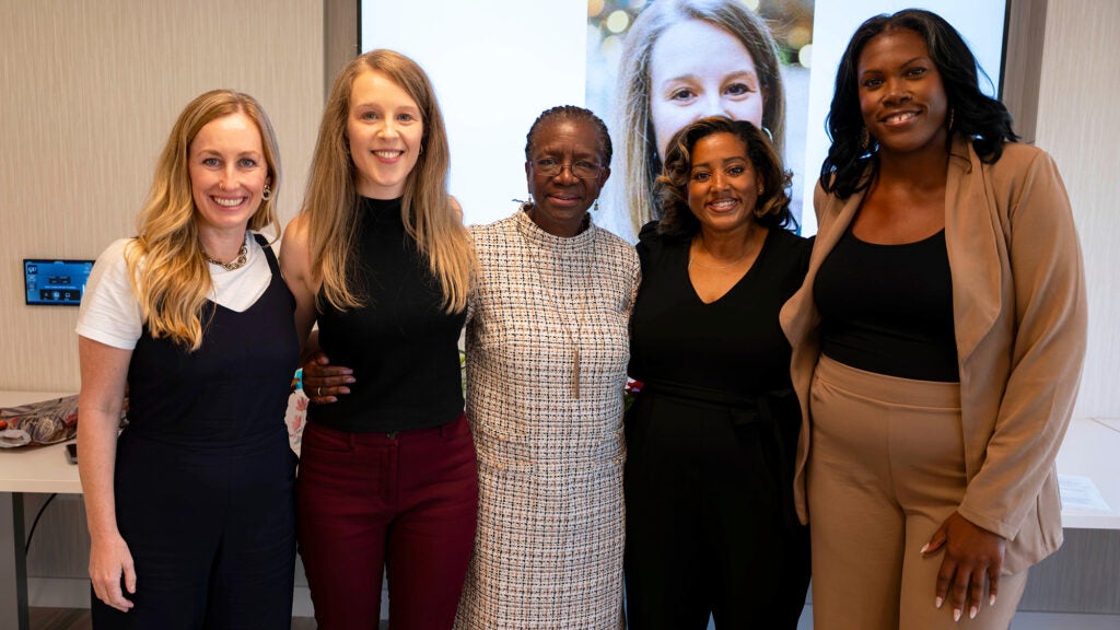The four PhD students plus Edlima Yearwood stand together