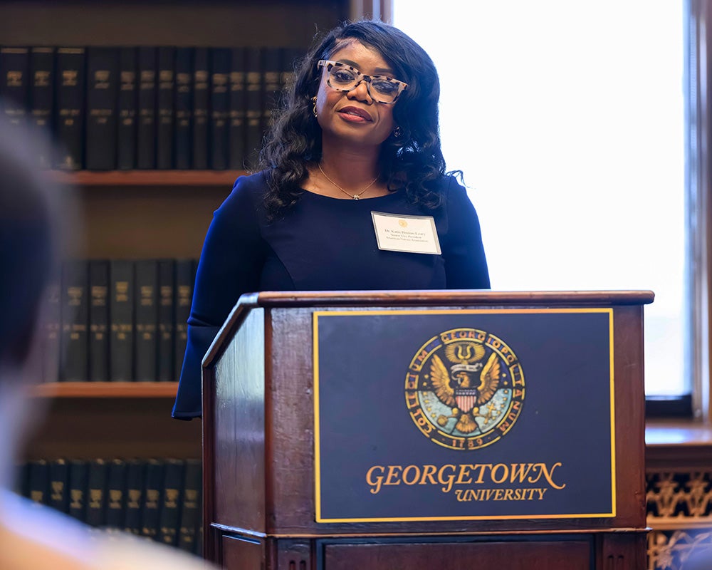 Katy Boston-Leary speaks from a podium in Riggs LIbrary