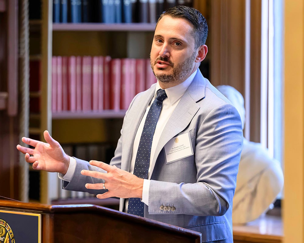 Bradley Goettl speaks from a podium in Riggs Library