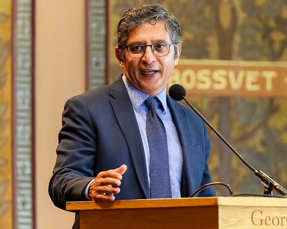 Sandeep Dahiya speaks from a podium in Gaston Hall