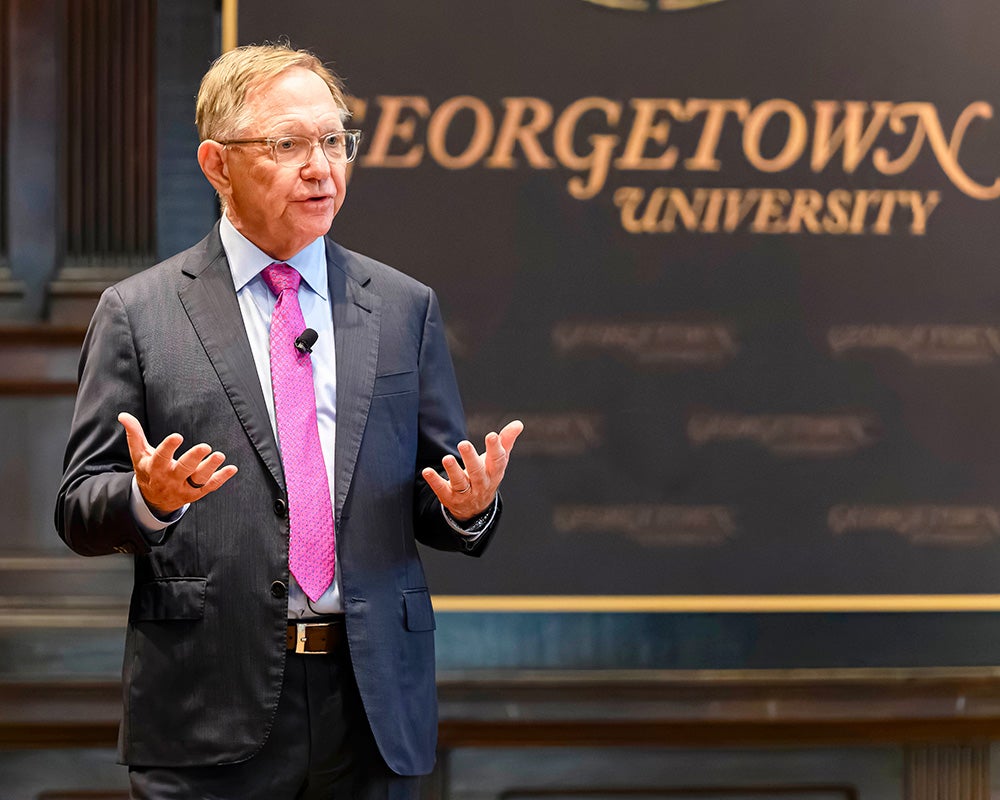 Quint Studer speaks from the stage in Gaston Hall