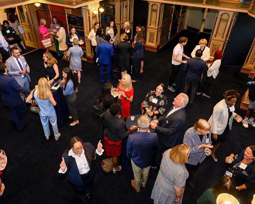 People mingle at tables in Riggs Library