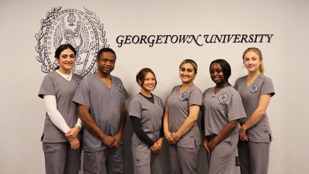 The six Washington Home scholarship winners stand together with the logo of the School of Nursing behind them on the wall