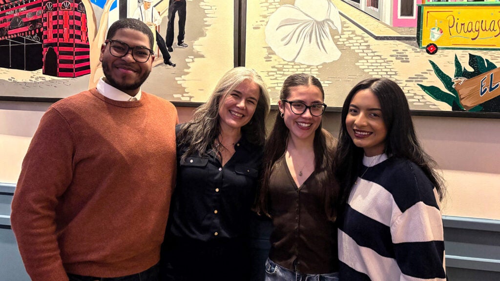 Three students stand with Dr. Mirabal-Beltran