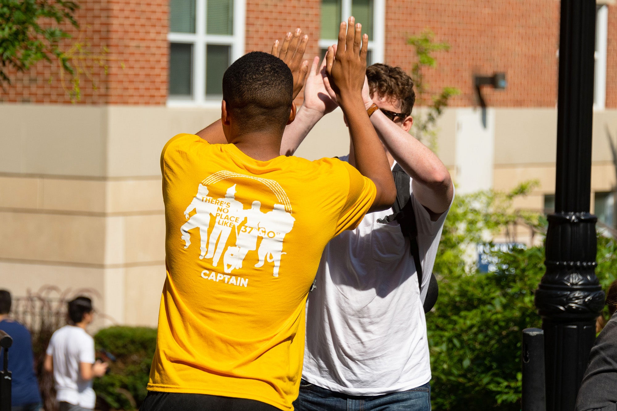 Two male students high five during move-in day