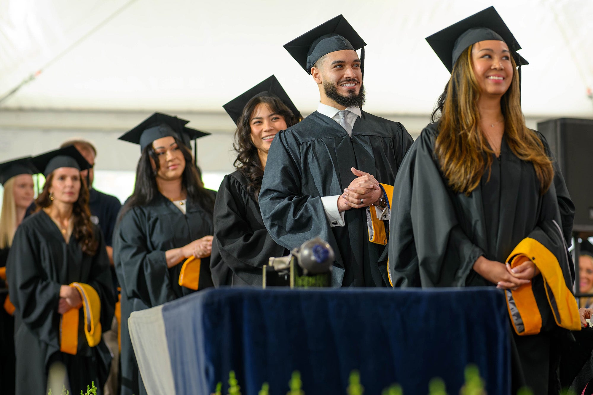 Students in caps and gowns await their diplomas