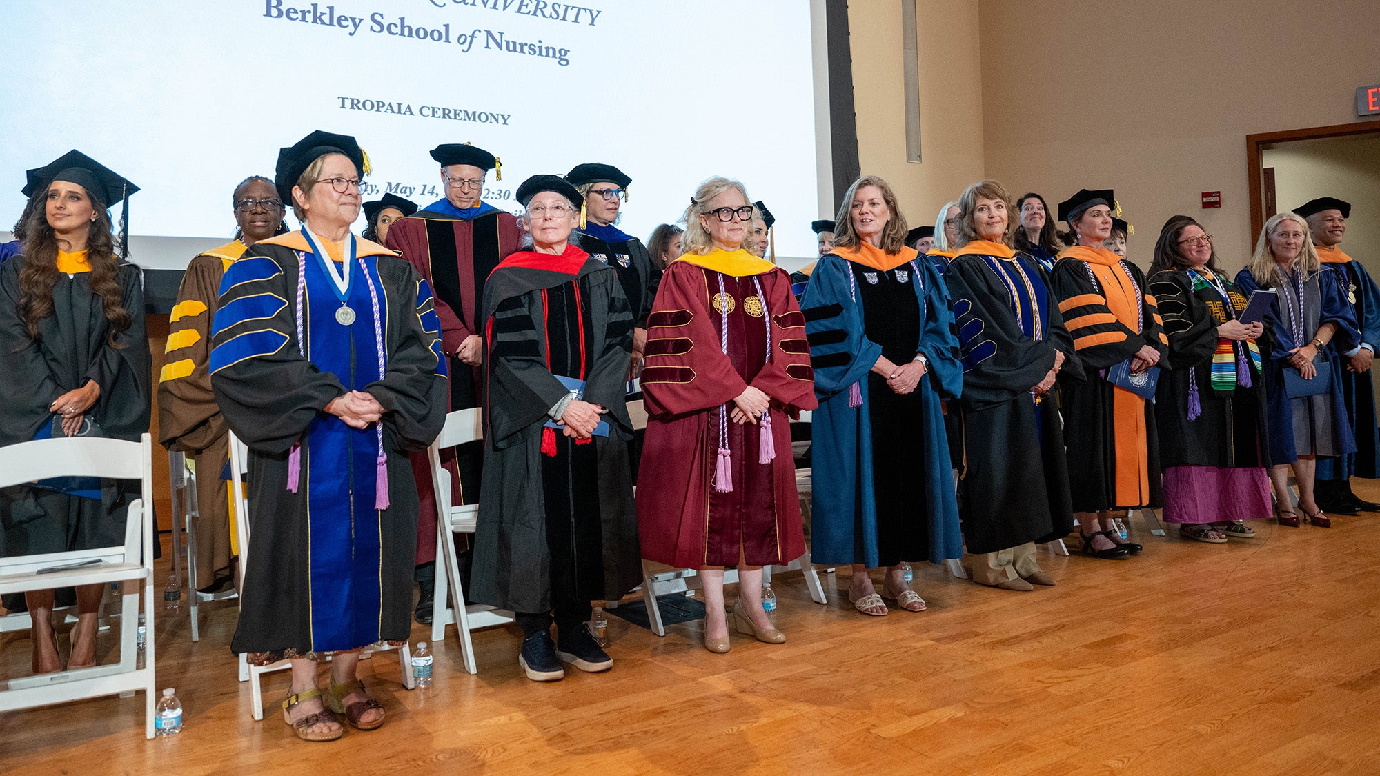 Faculty line up on the stage during the 2026 Tropaia