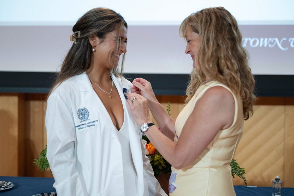 Penny Capuano attaches a pin to her daughter's white coat